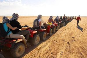 Quad bike desert safari tour in Hurghada with tourists riding ATVs in the desert
